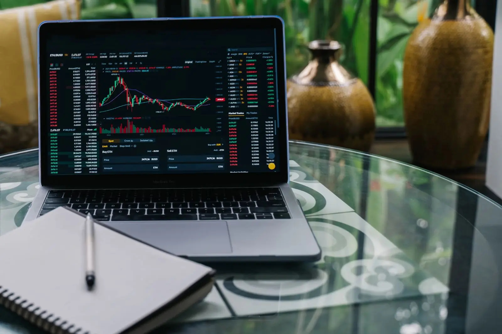 Trader at a desk with a laptop and a notebook, planning position sizes for a small trading account
