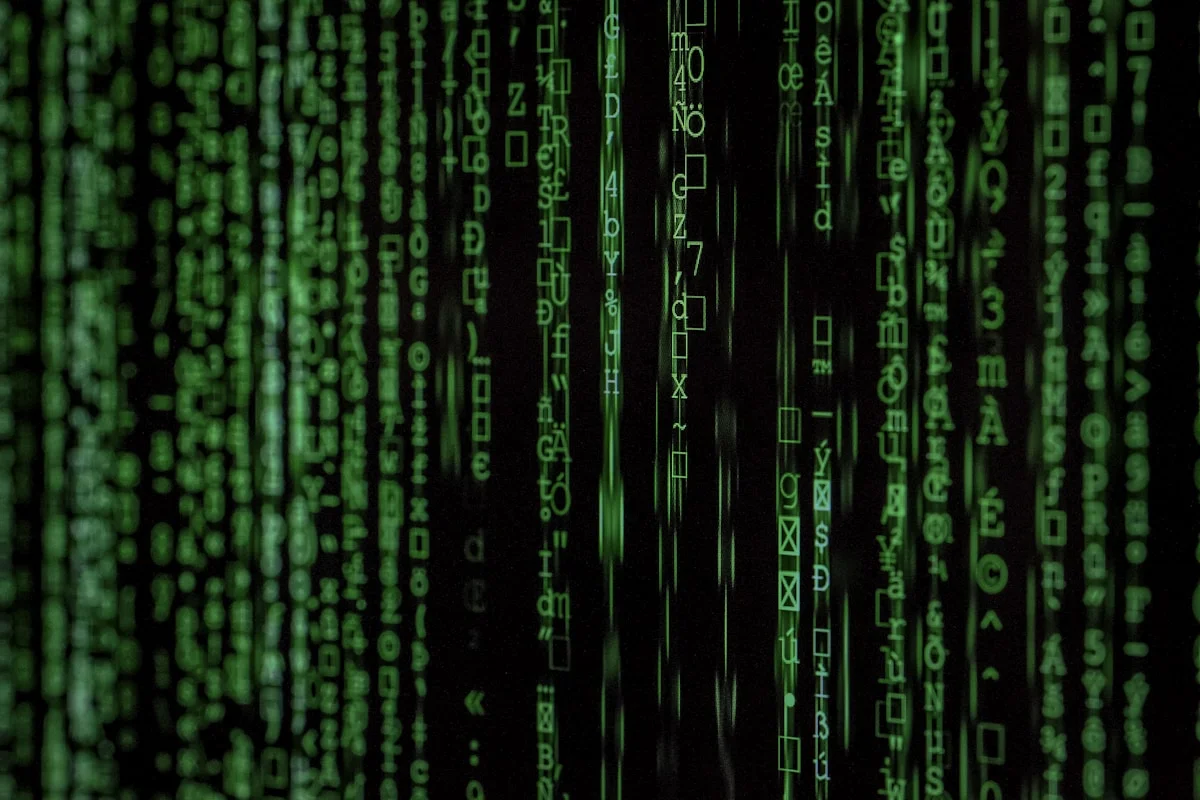 Green data streams and code on a dark screen representing API connectivity and algorithmic trading infrastructure.
