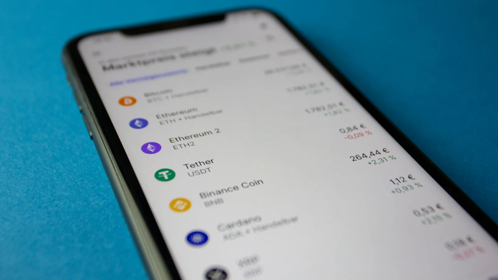 A smartphone showing a list of crypto prices and daily changes