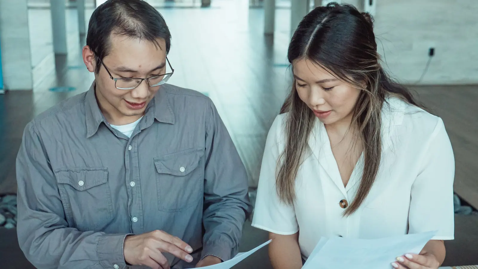 Two colleagues reviewing printed reports together
