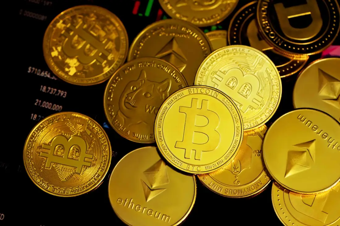 A pile of gold and silver crypto coins representing prop firm payouts and profit splits