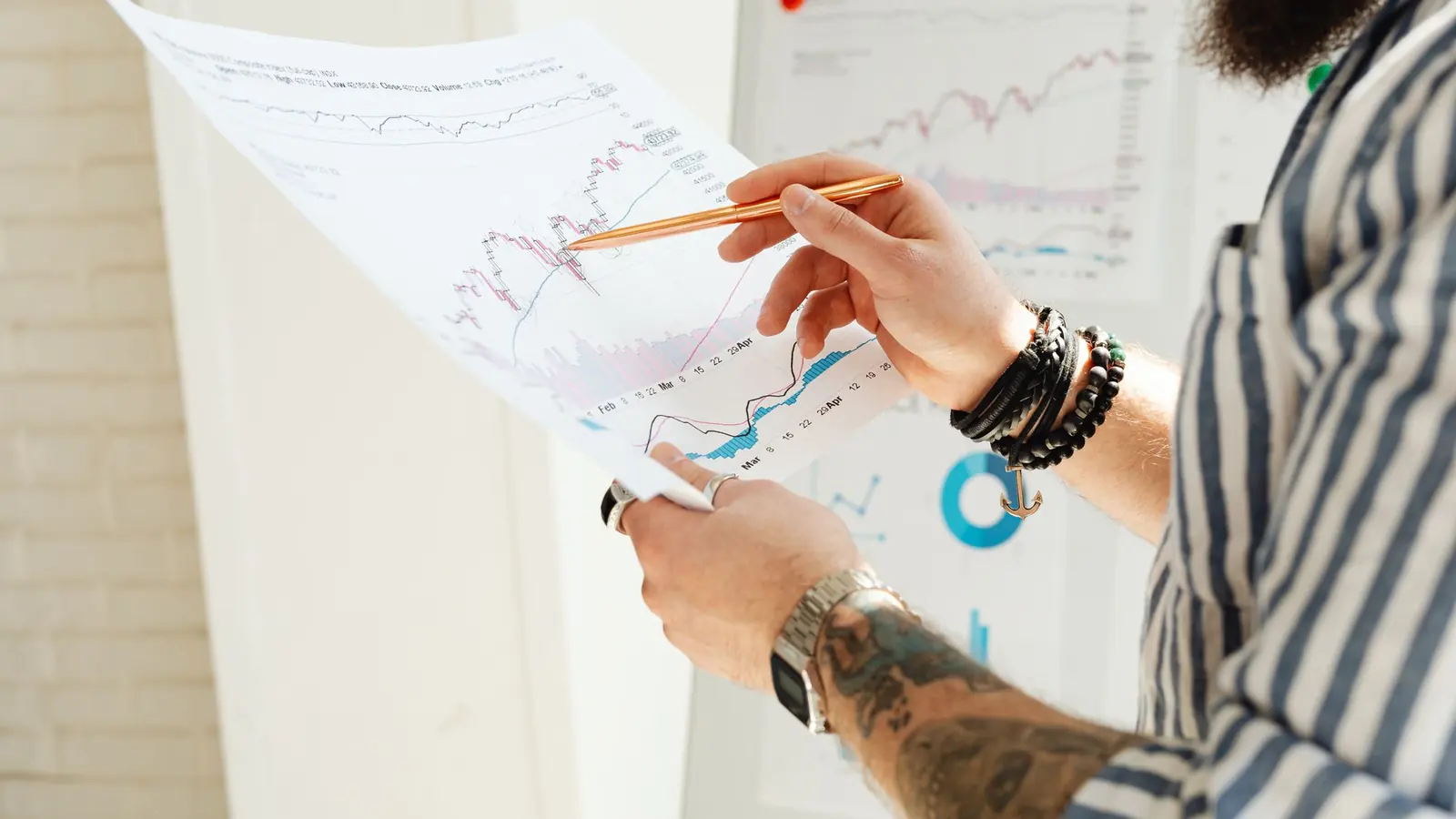 A trader marking levels on a printed price chart with a pencil