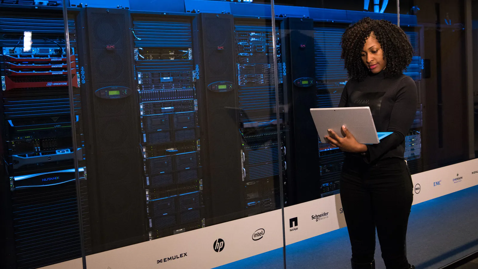 A technician checking server racks with a laptop