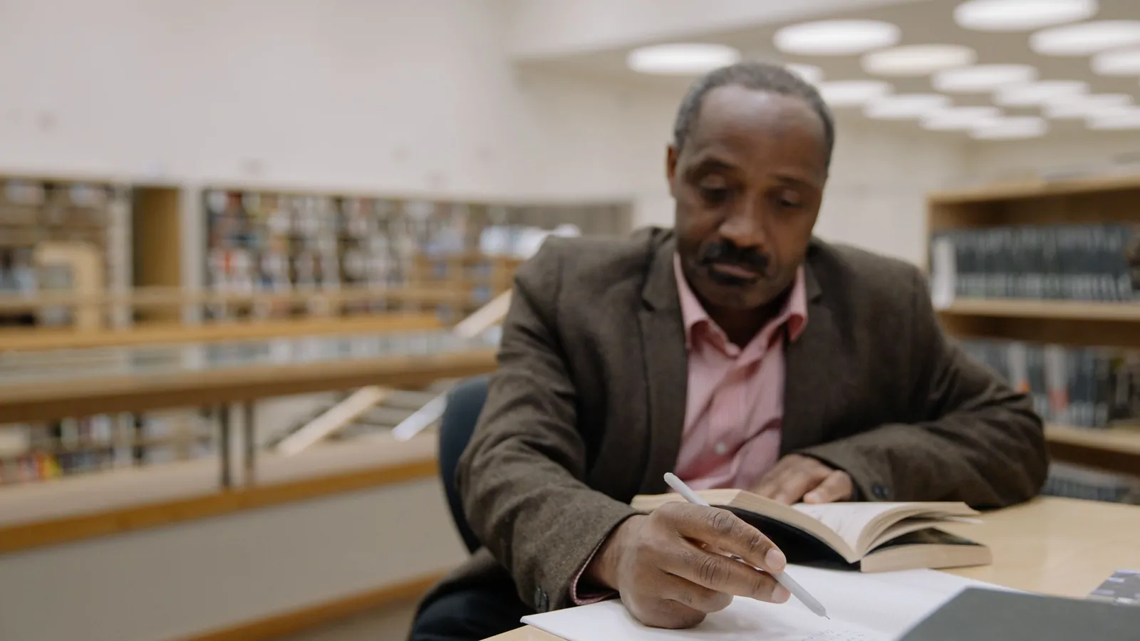 A trader studying and taking notes at a desk