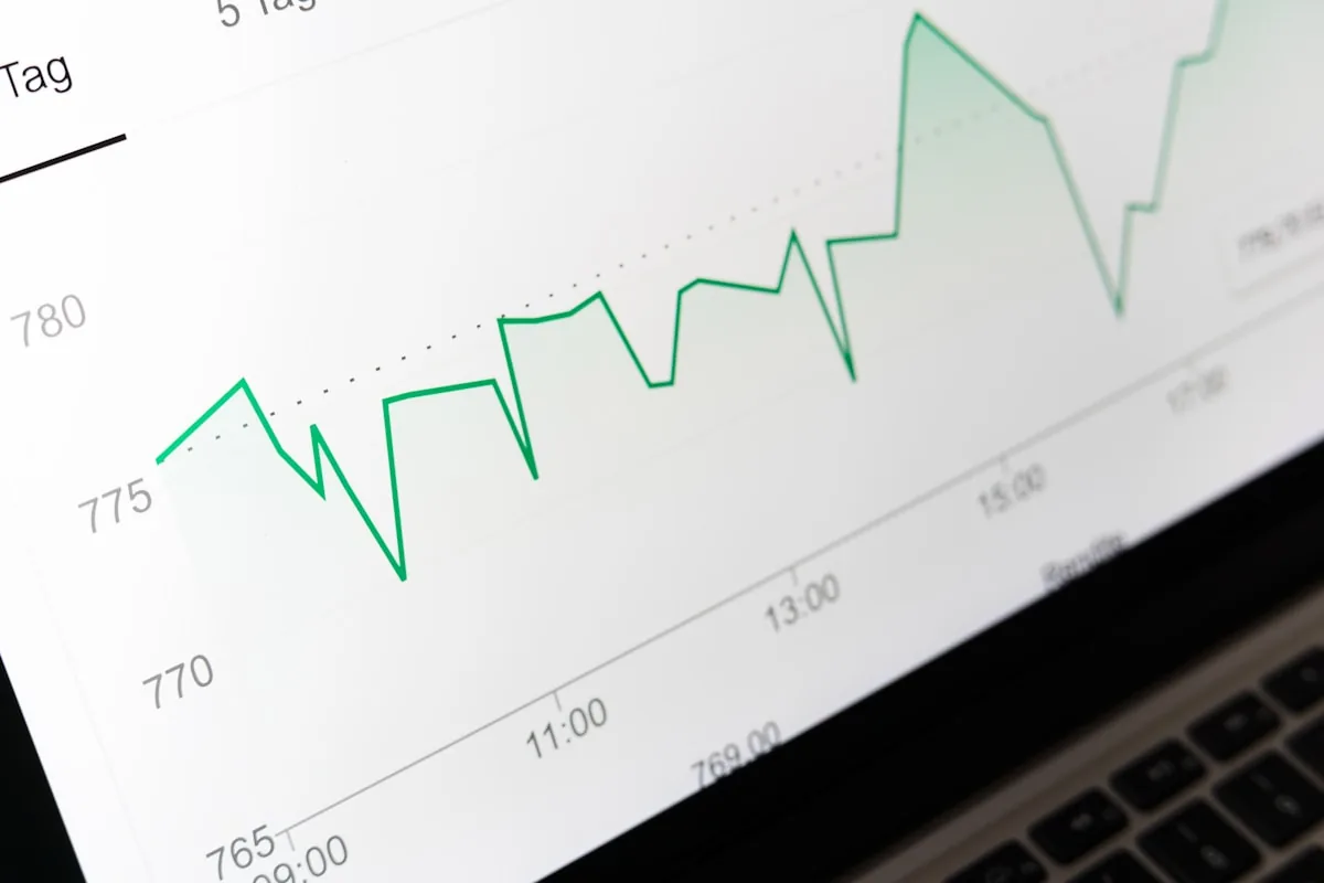 A green upward trading chart on a laptop screen