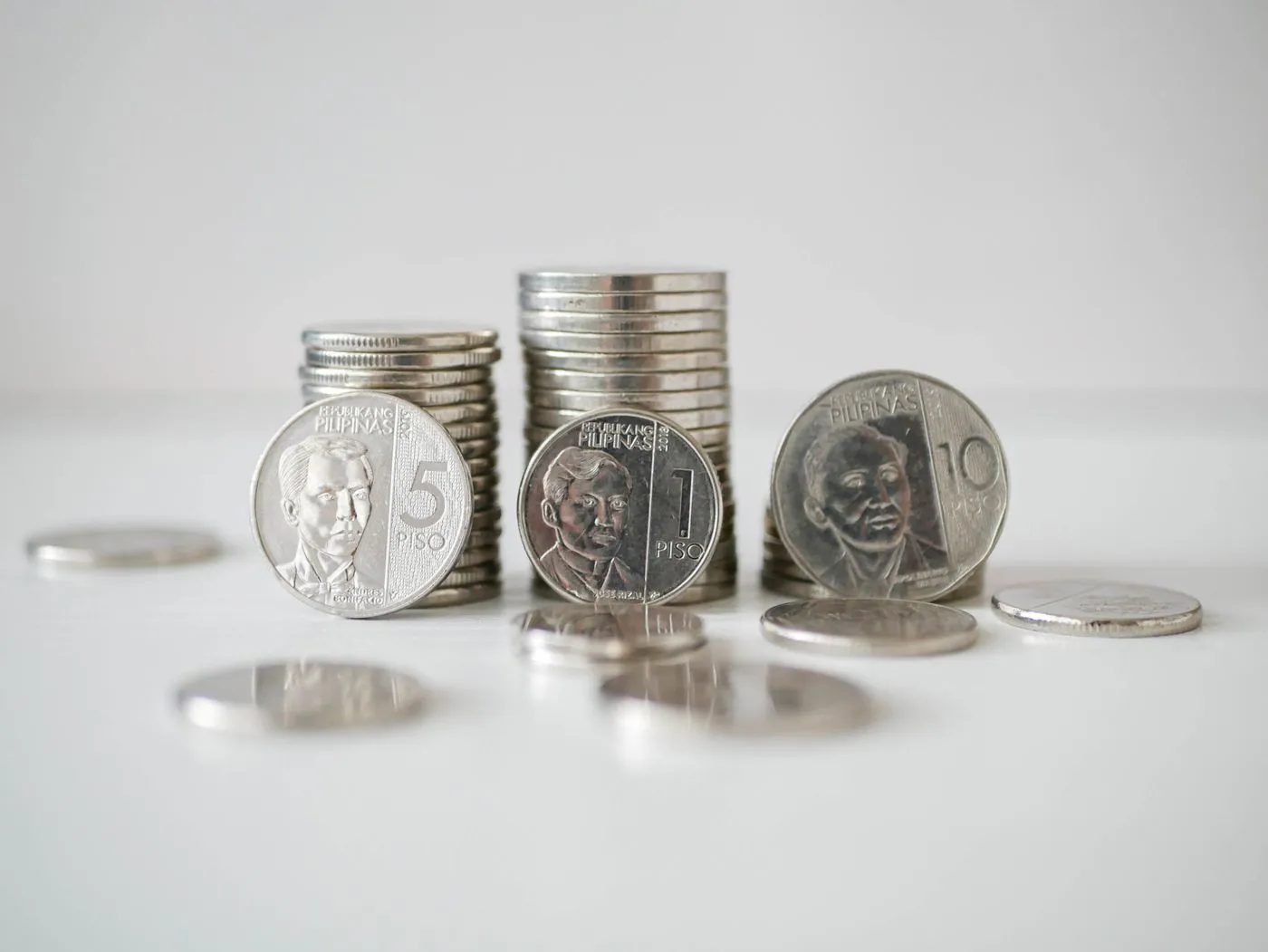 Stacks of silver coins on a light background