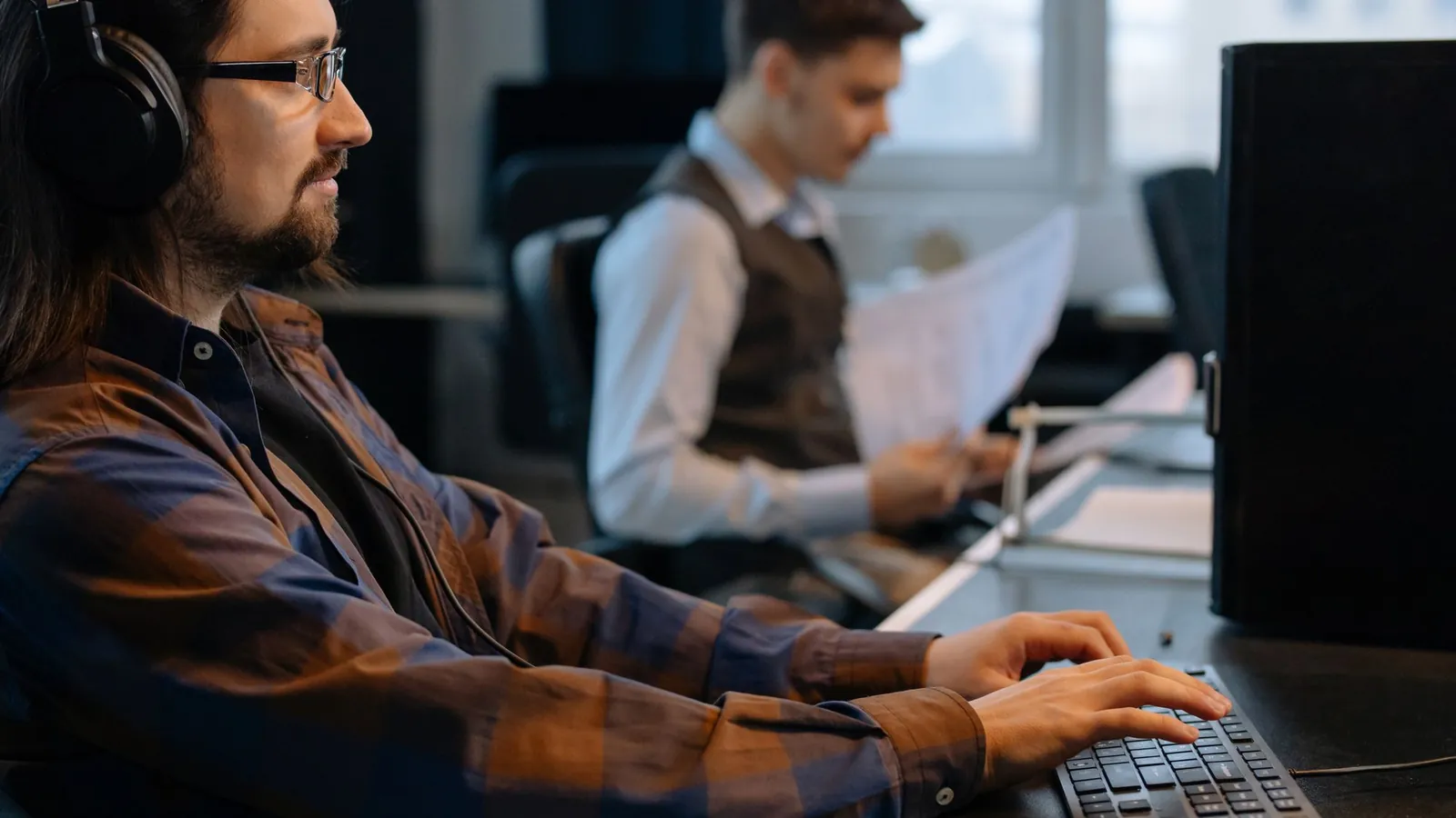 Office staff checking trades and paperwork at their desks