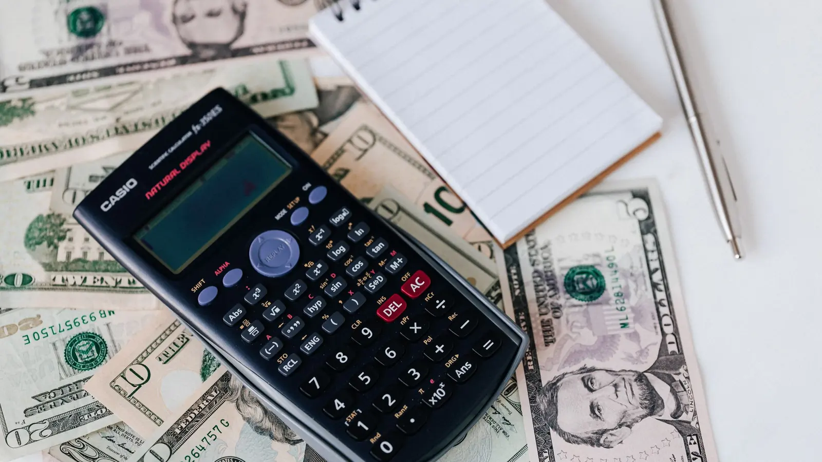 A calculator lying on US dollar bills