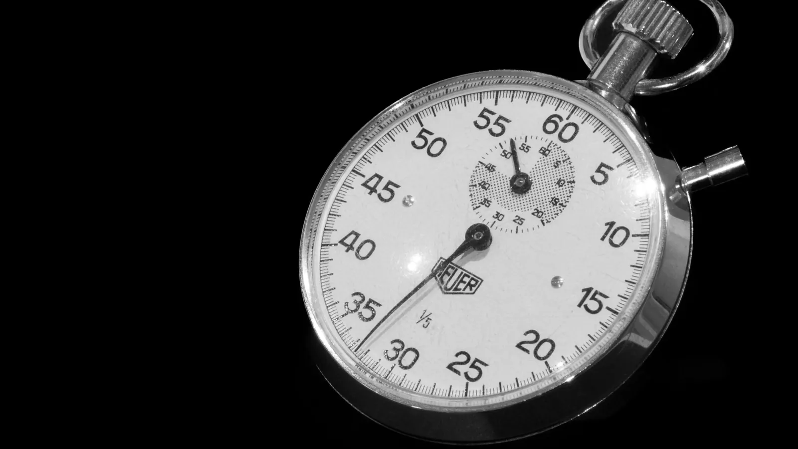 A vintage mechanical stopwatch on a black background