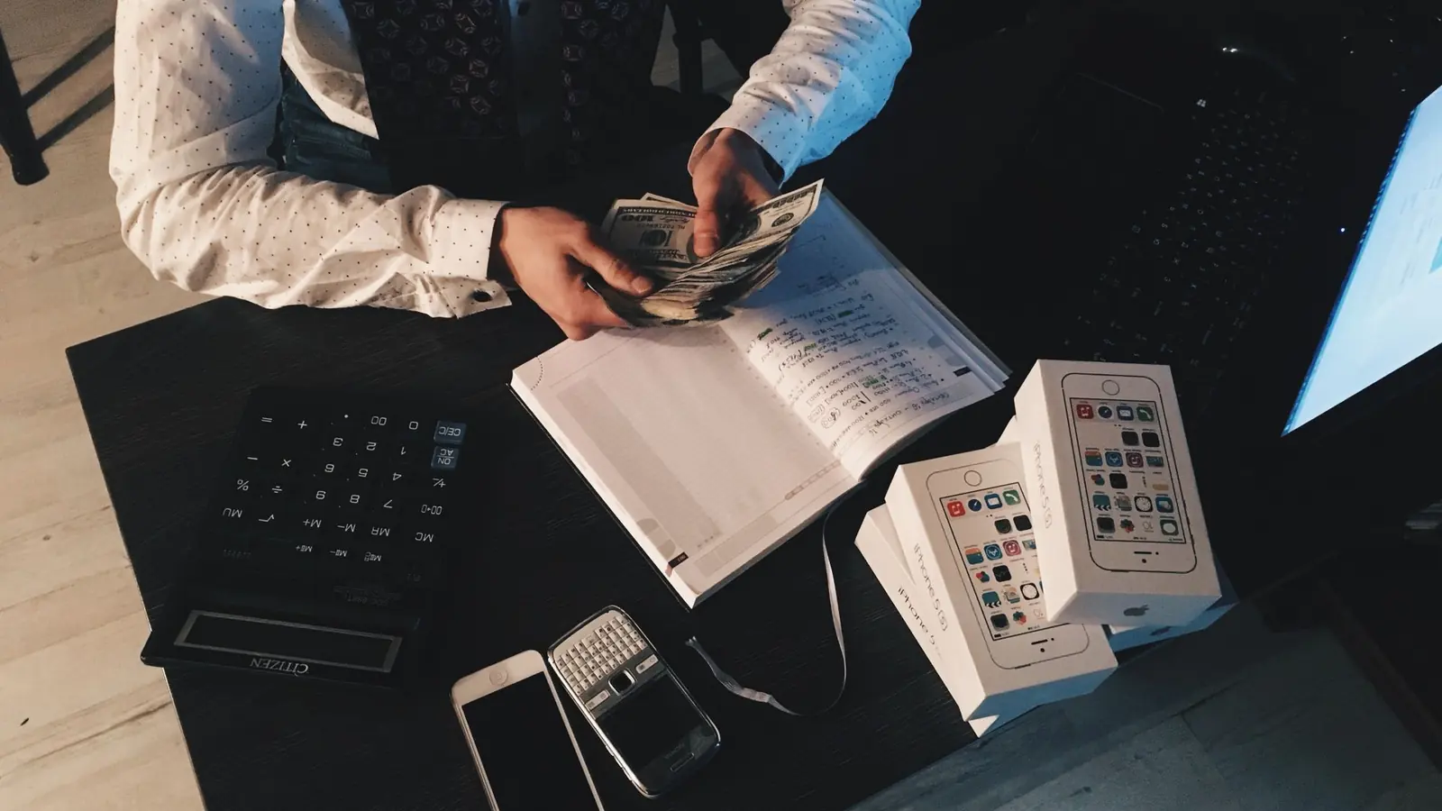 A trader's desk with a phone, notebook and papers