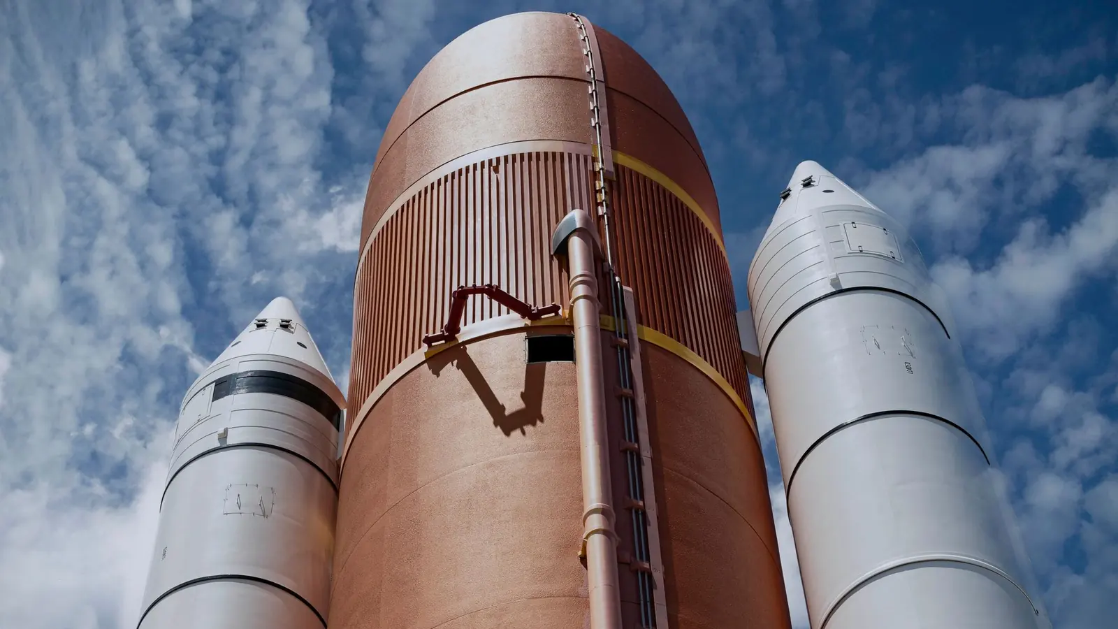 Rocket boosters on a launch pad against a cloudy sky