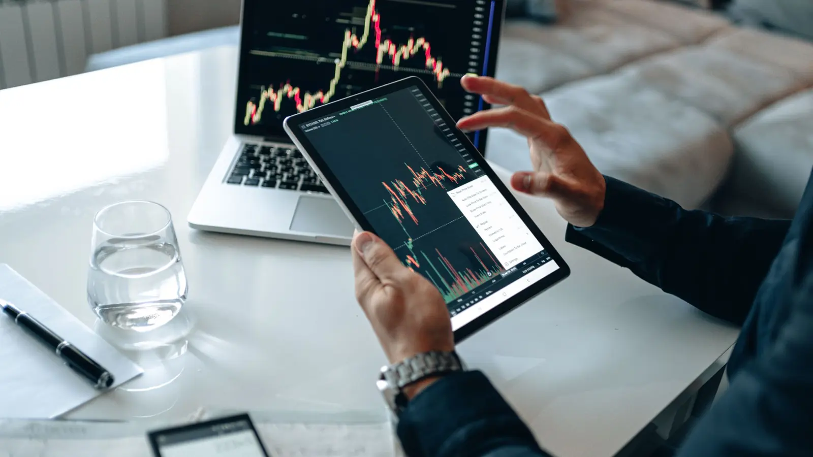 A trader checking a candlestick chart on a tablet
