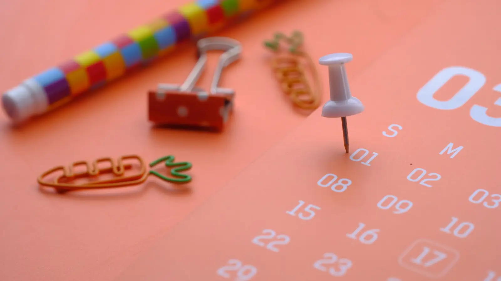 A calendar page with a push pin marking a date