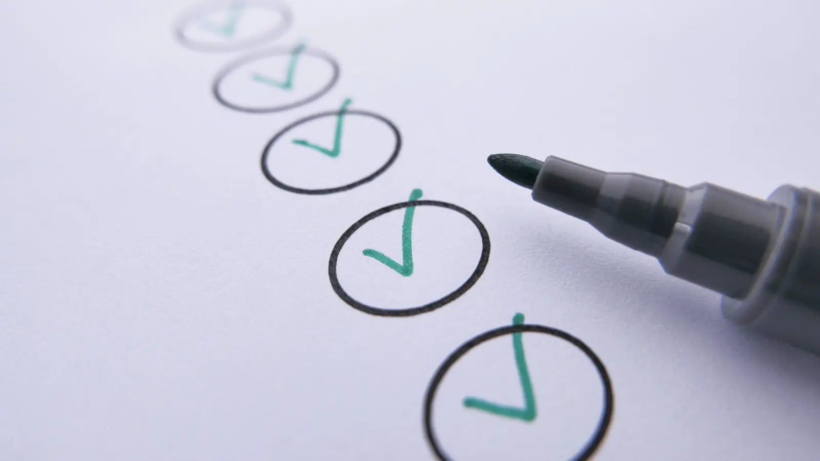 A pen ticking boxes on a checklist