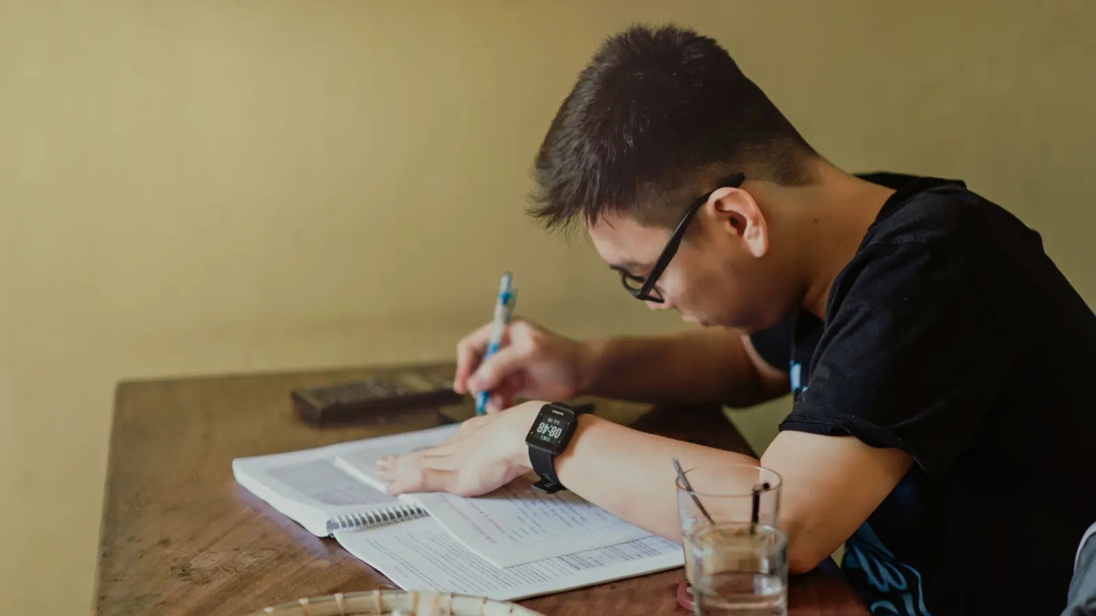 A trader writing notes in a notebook at a desk
