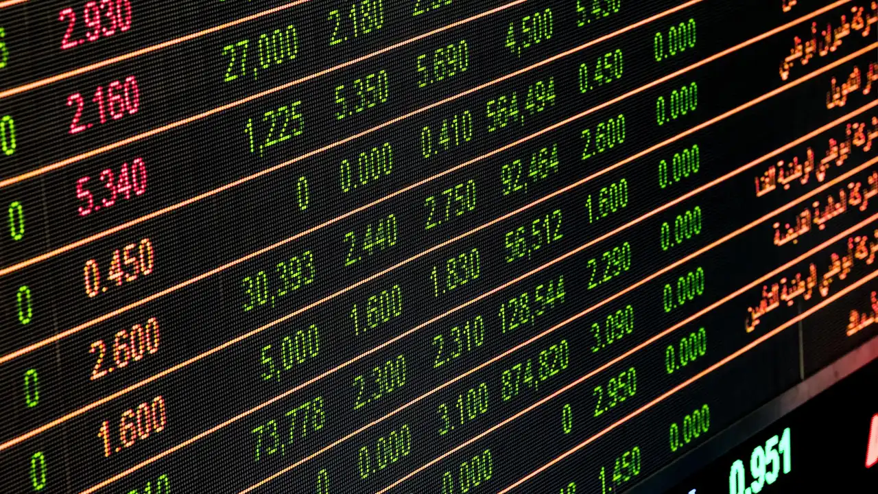 An electronic board showing live market prices in red and green